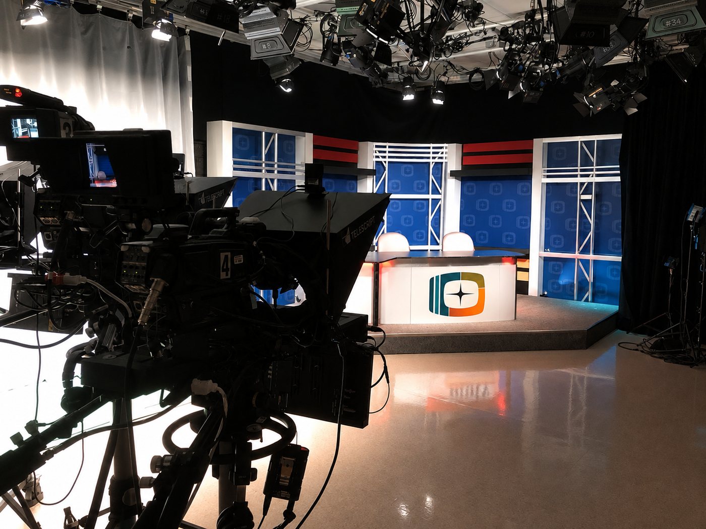 On Camera Creative studio set in The Hague, with camera, teleprompter and branded anchor desk
